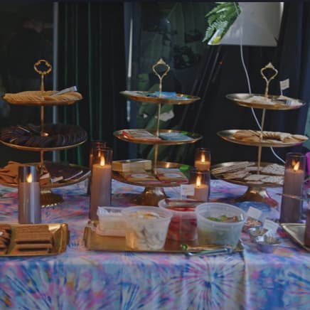 Tiered gold trays of s'mores ingredients on a candlelit table